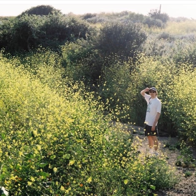 Portrait of Cameron standing in a field of yellow flowers